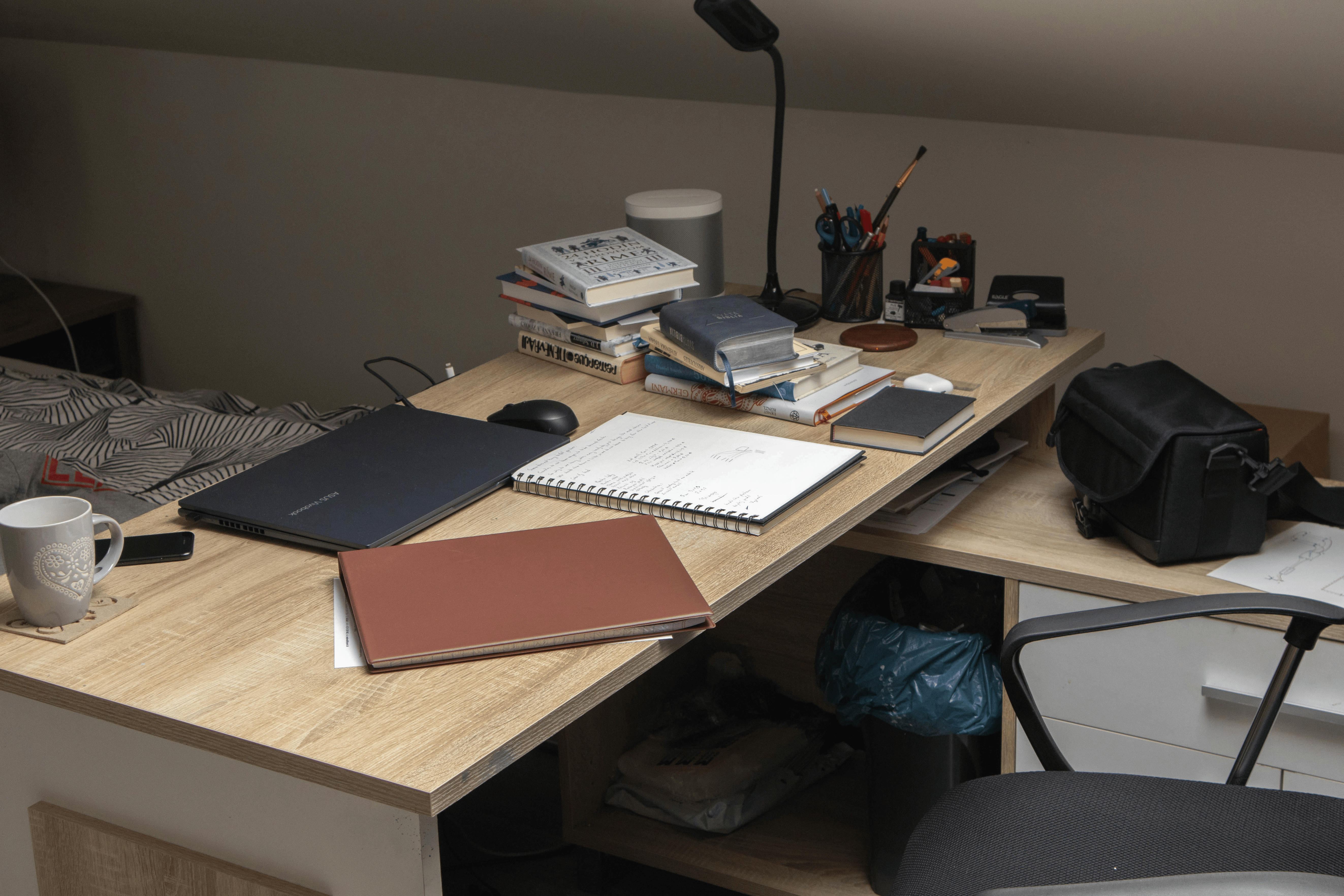 Minimalist desk workspace with open notebooks, stacked books and a lamp, blog post by Golam Sayon Ahamed on design thinking process